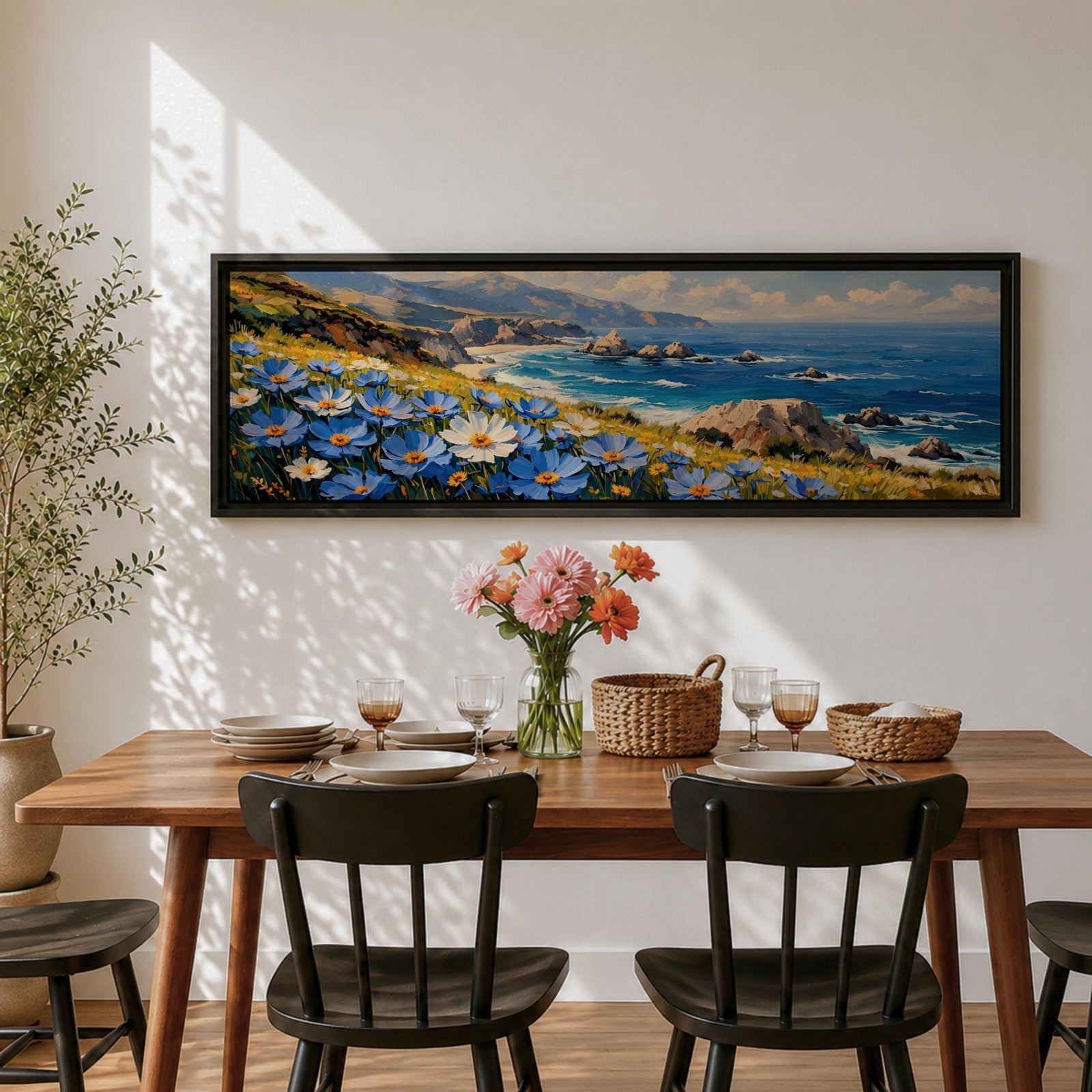 A panoramic coastal landscape painting showing blue and white wildflowers blooming along a grassy cliff overlooking a rocky shoreline and deep blue ocean waves, with distant mountains and scattered sea stacks beneath a bright sky stretching across the wide horizontal composition.