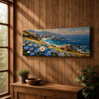 A panoramic coastal landscape painting showing blue and white wildflowers blooming along a grassy cliff overlooking a rocky shoreline and deep blue ocean waves, with distant mountains and scattered sea stacks beneath a bright sky stretching across the wide horizontal composition.