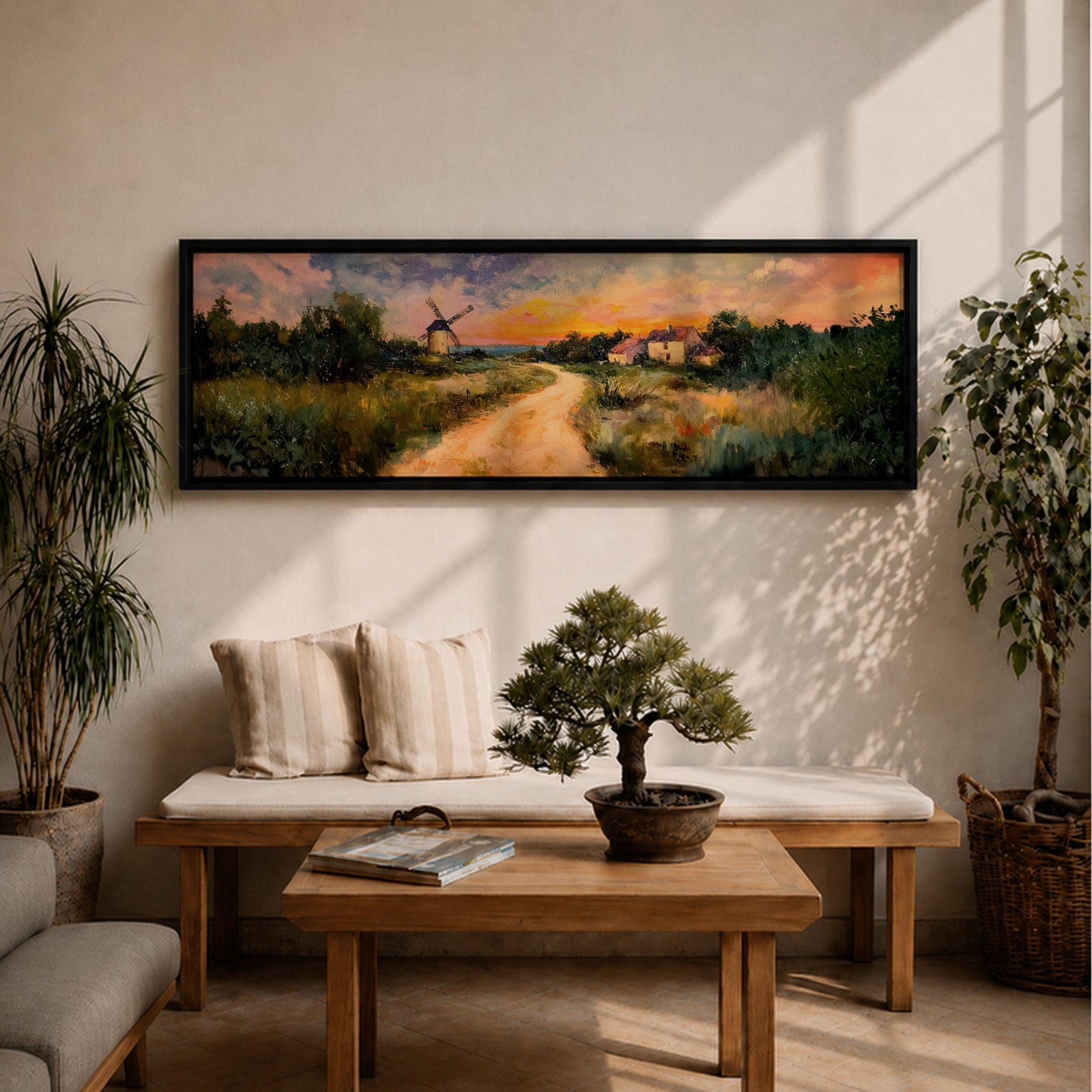 A panoramic countryside landscape painting showing a winding dirt road leading through grassy fields toward a traditional windmill and small farmhouse under a glowing sunset sky, with soft clouds and warm golden light illuminating the rural scenery across the wide composition.