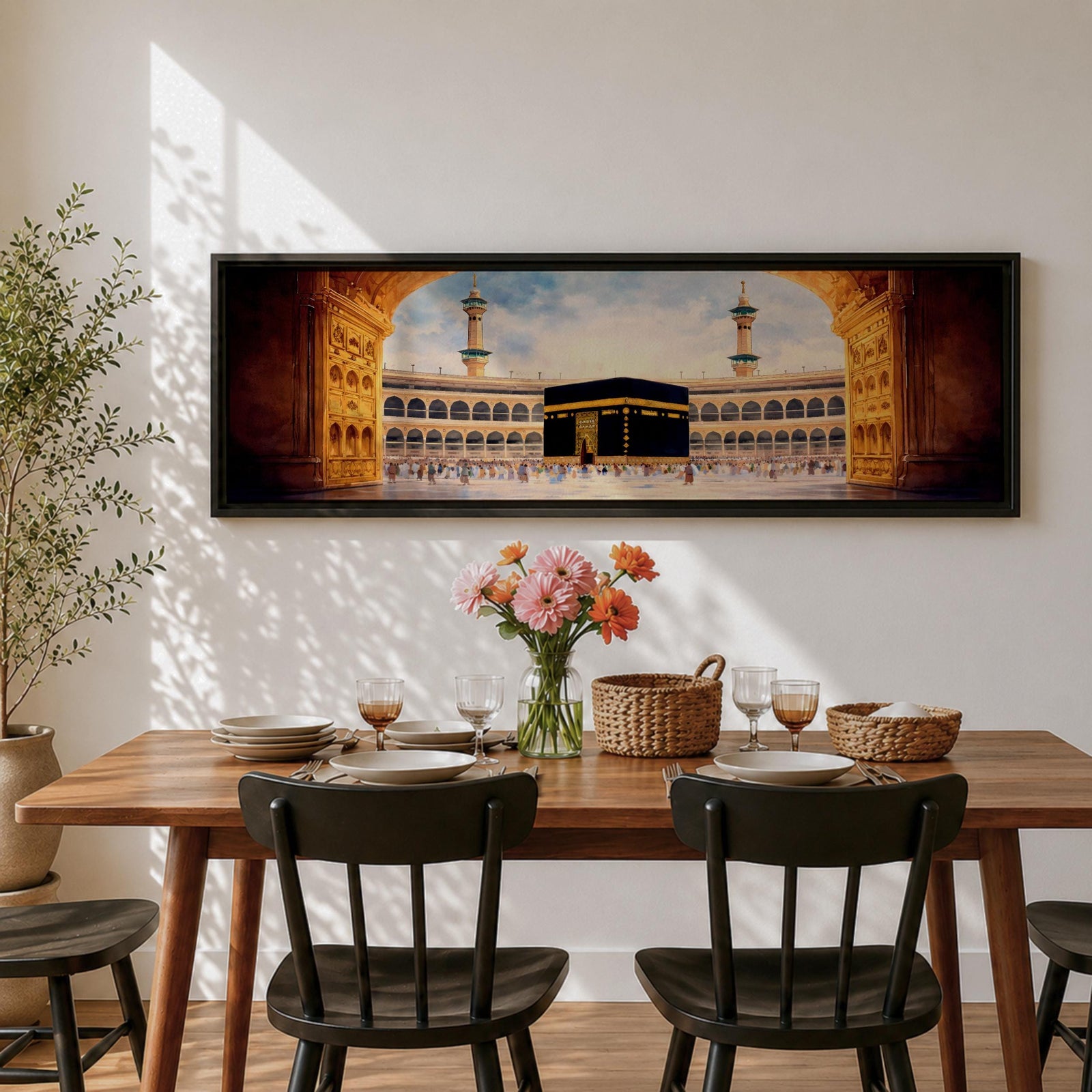 A long panoramic artwork depicting the Kaaba at the center of Masjid Al Haram in Mecca framed by grand mosque arches and tall minarets. The sacred black cube stands in the courtyard while pilgrims gather around it, creating a wide horizontal composition highlighting the holy Islamic sanctuary.
