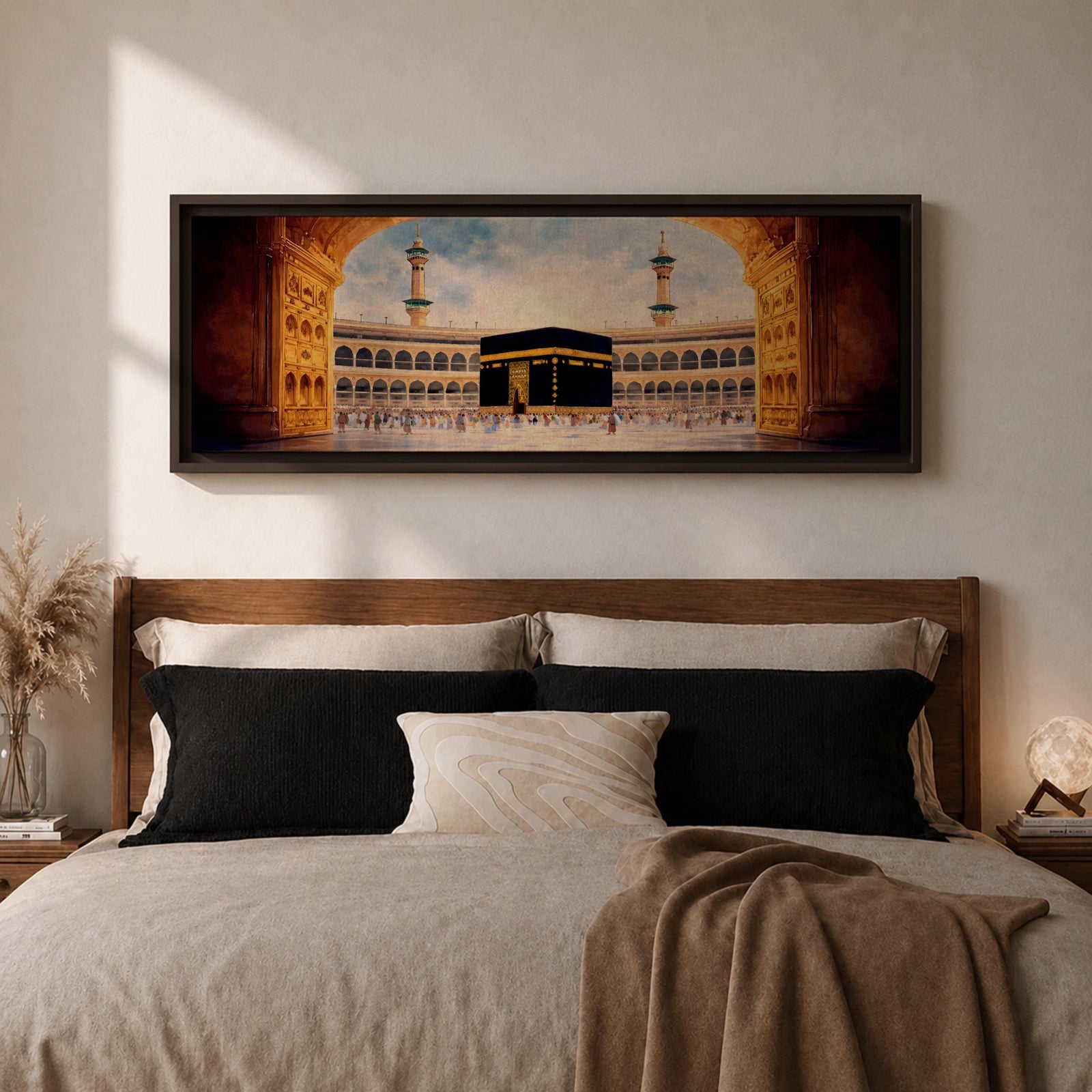 A long panoramic artwork depicting the Kaaba at the center of Masjid Al Haram in Mecca framed by grand mosque arches and tall minarets. The sacred black cube stands in the courtyard while pilgrims gather around it, creating a wide horizontal composition highlighting the holy Islamic sanctuary.