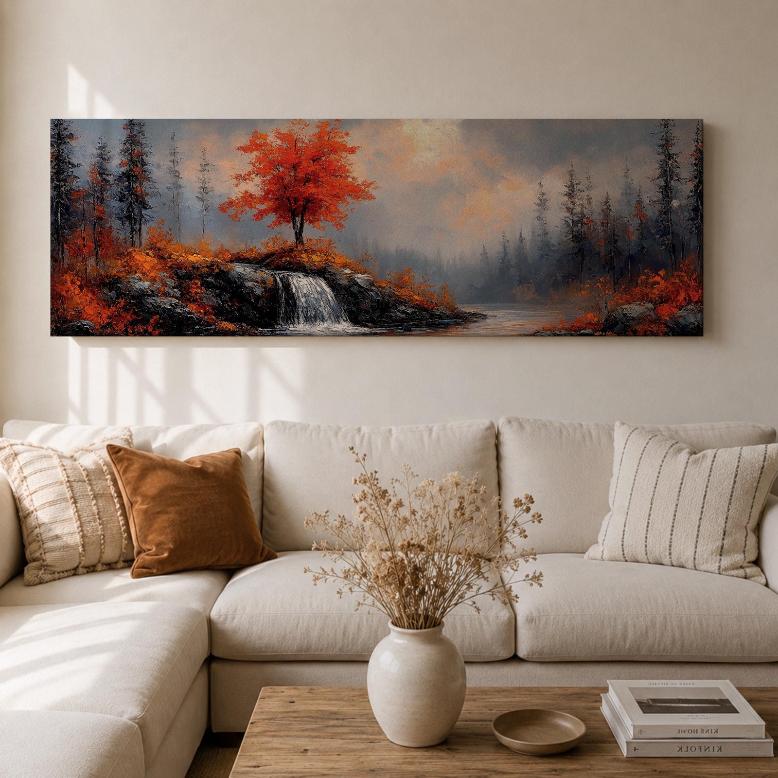 A long panoramic landscape painting showing a small waterfall flowing over rocky cliffs beneath a vivid red autumn tree. Surrounding forest trees fade into misty blue tones while bright fall foliage and rugged stones frame the stream, forming a tranquil woodland scene across a wide horizontal composition.