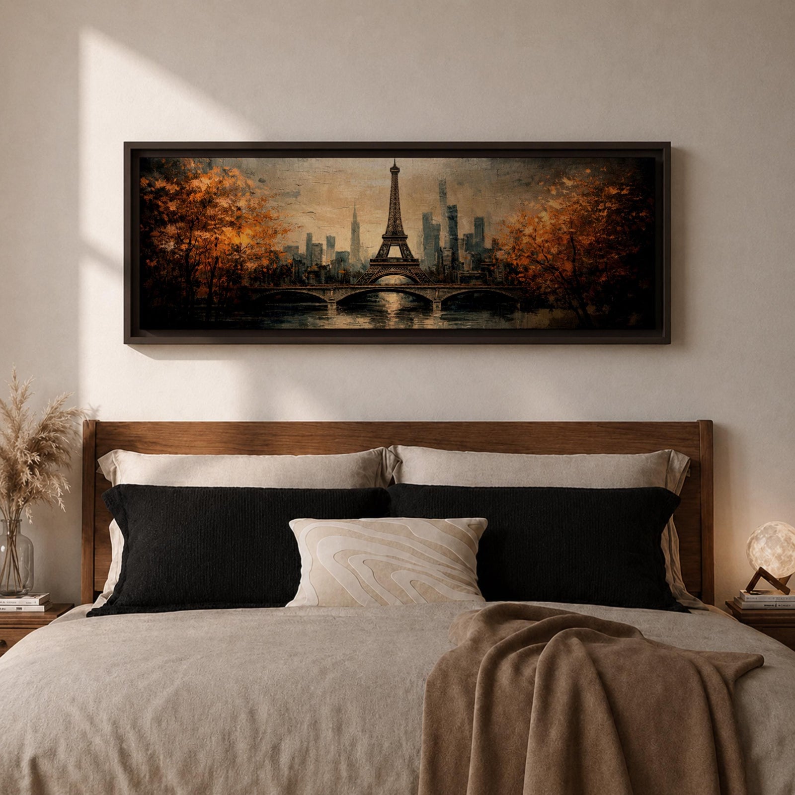 A long narrow panoramic painting depicts the Eiffel Tower rising above a river with an arched bridge in the foreground, surrounded by autumn trees and a distant city skyline, rendered in textured brushstrokes with warm golden tones and soft reflections that create depth and a romantic atmospheric cityscape.