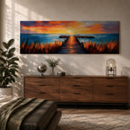 A long narrow panoramic painting depicts a wooden pier extending through tall grasses into calm ocean waters, leading toward a glowing sunset on the horizon, with bold textured brushstrokes and vivid color contrasts capturing reflections of warm light across the water and sky in an expressive contemporary style.