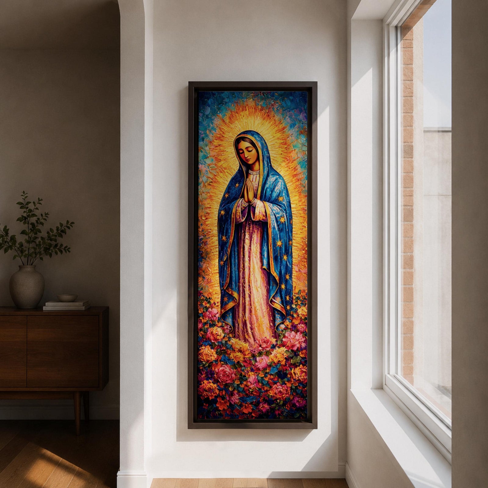 A tall narrow vertical depiction of Our Lady of Guadalupe standing in prayer with hands clasped, wearing a blue star covered mantle and soft pink gown, surrounded by a radiant golden sunburst and dense vibrant floral arrangement at her feet, rendered with rich texture and layered color in a devotional composition.