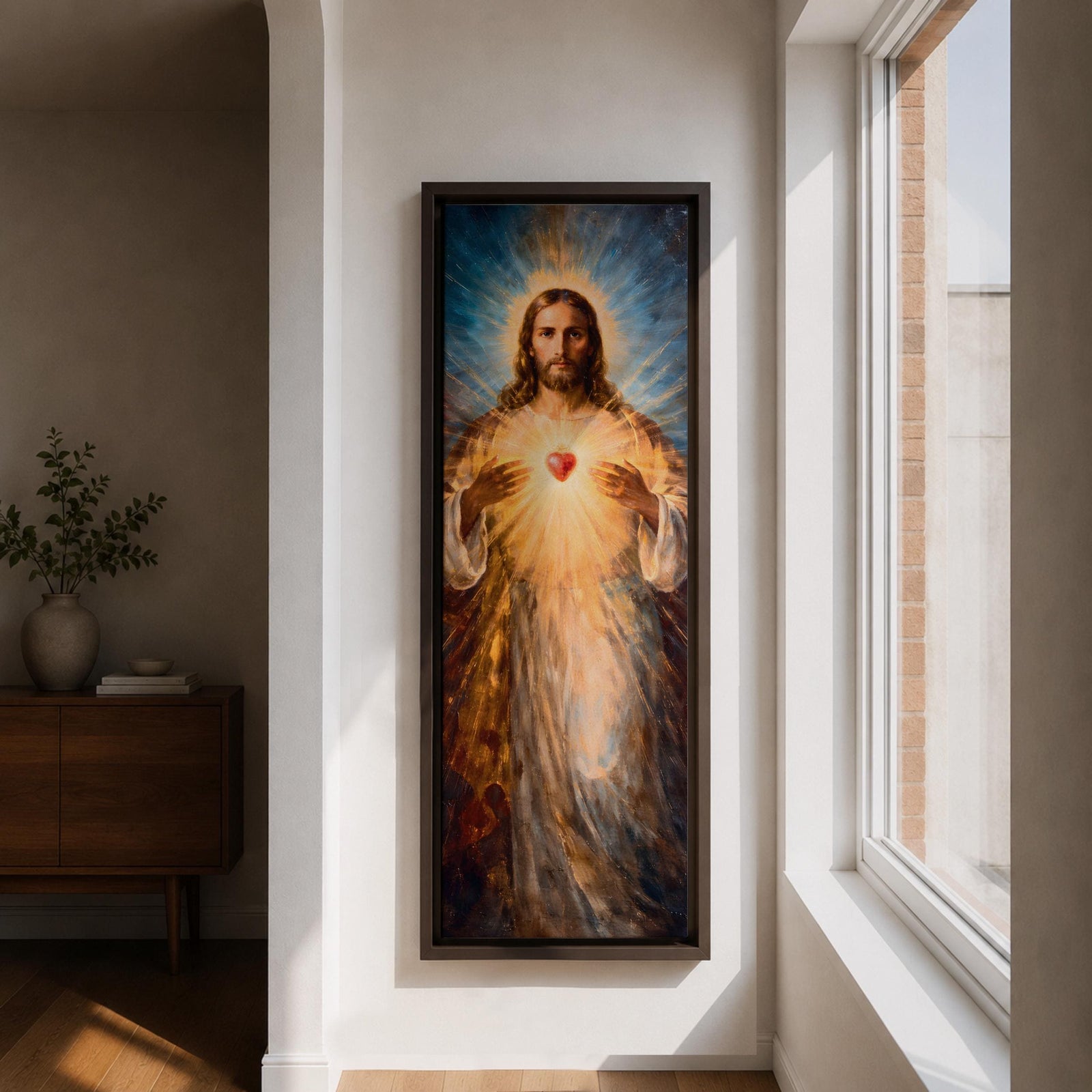A tall vertical painting depicts Jesus Christ with a serene expression, long flowing hair, and a radiant halo, holding a glowing sacred heart at his chest that emits beams of golden light, rendered in warm tones with soft brushwork and luminous effects that create a spiritual and symbolic religious composition.