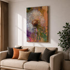 Close-up of a dandelion seed head with fine white filaments against a colorful abstract background featuring warm tones of orange, purple, and green, rendered in an abstract botanical style on a framed canvas.