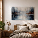 A framed canvas painting depicting a serene winter lake landscape with bare trees reflected in still water. The scene features a quiet woodland setting with leafless trees and subtle earthy tones, capturing the calm and reflective nature of a winter forest by the lake.
