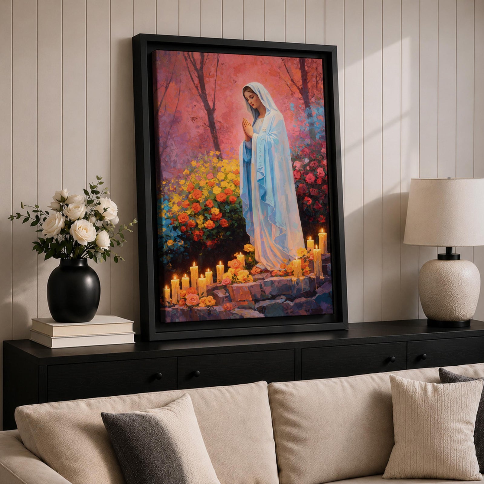 A detailed painting of Our Lady of Lourdes depicts the Virgin Mary standing with hands clasped in prayer, surrounded by blooming flowers and lit candles. The image captures a serene religious scene symbolizing the Marian apparition, rendered in a realistic style with vibrant colors and soft shading.