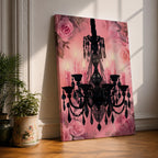 A framed canvas print featuring a detailed black chandelier silhouette with multiple hanging crystals and candle flames, set against a pink floral background with roses, blending ornate lighting design with a soft botanical motif.