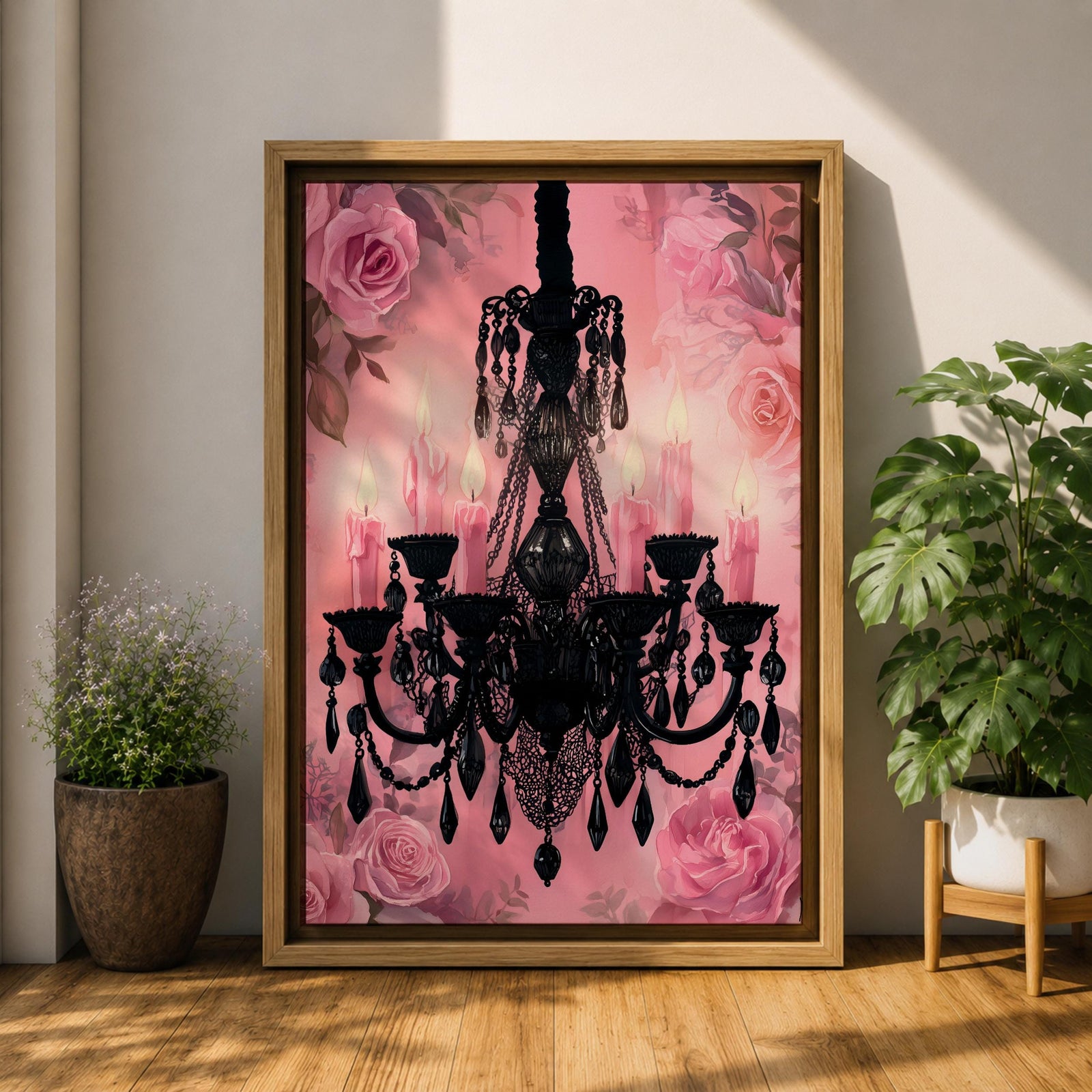 A framed canvas print featuring a detailed black chandelier silhouette with multiple hanging crystals and candle flames, set against a pink floral background with roses, blending ornate lighting design with a soft botanical motif.