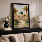 Framed canvas wall art of the Prophet’s Mosque in Medina featuring the iconic green dome, surrounded by palm trees and blooming pink flowers along a sunlit garden path, creating a peaceful and serene Islamic landscape scene for home decor.