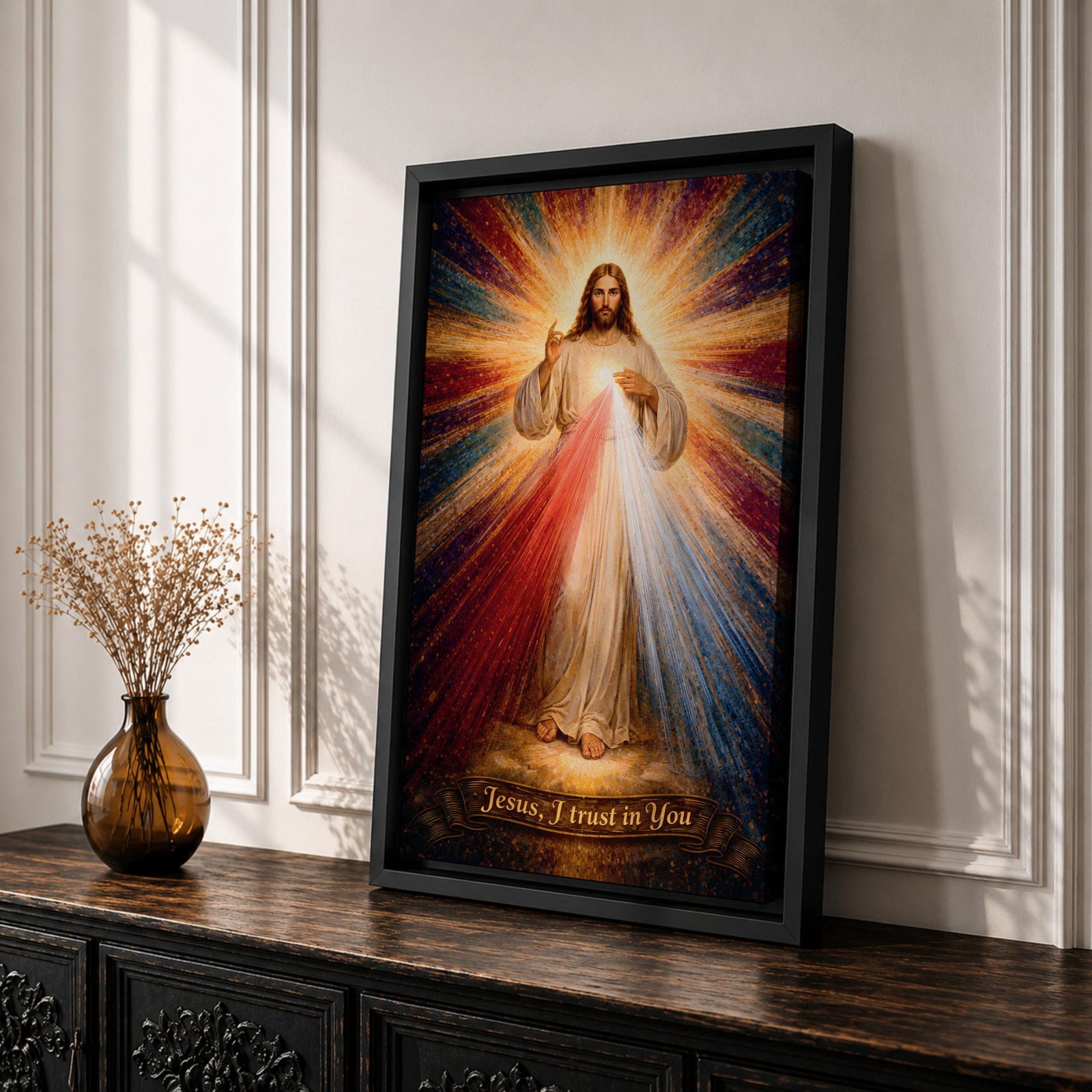 A radiant depiction of Divine Mercy of Jesus shows Jesus standing with one hand raised in blessing and the other pointing to his heart, from which red and pale rays emanate. The figure is surrounded by vibrant rays of light, rendered in a classical religious art style on canvas.