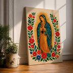 A framed stitched style art print depicting Our Lady of Guadalupe with hands clasped in prayer, surrounded by a radiant golden halo and vibrant floral embroidery in red, blue, and green. The image captures the traditional Mexican Catholic iconography with intricate textile detail and a serene expression.