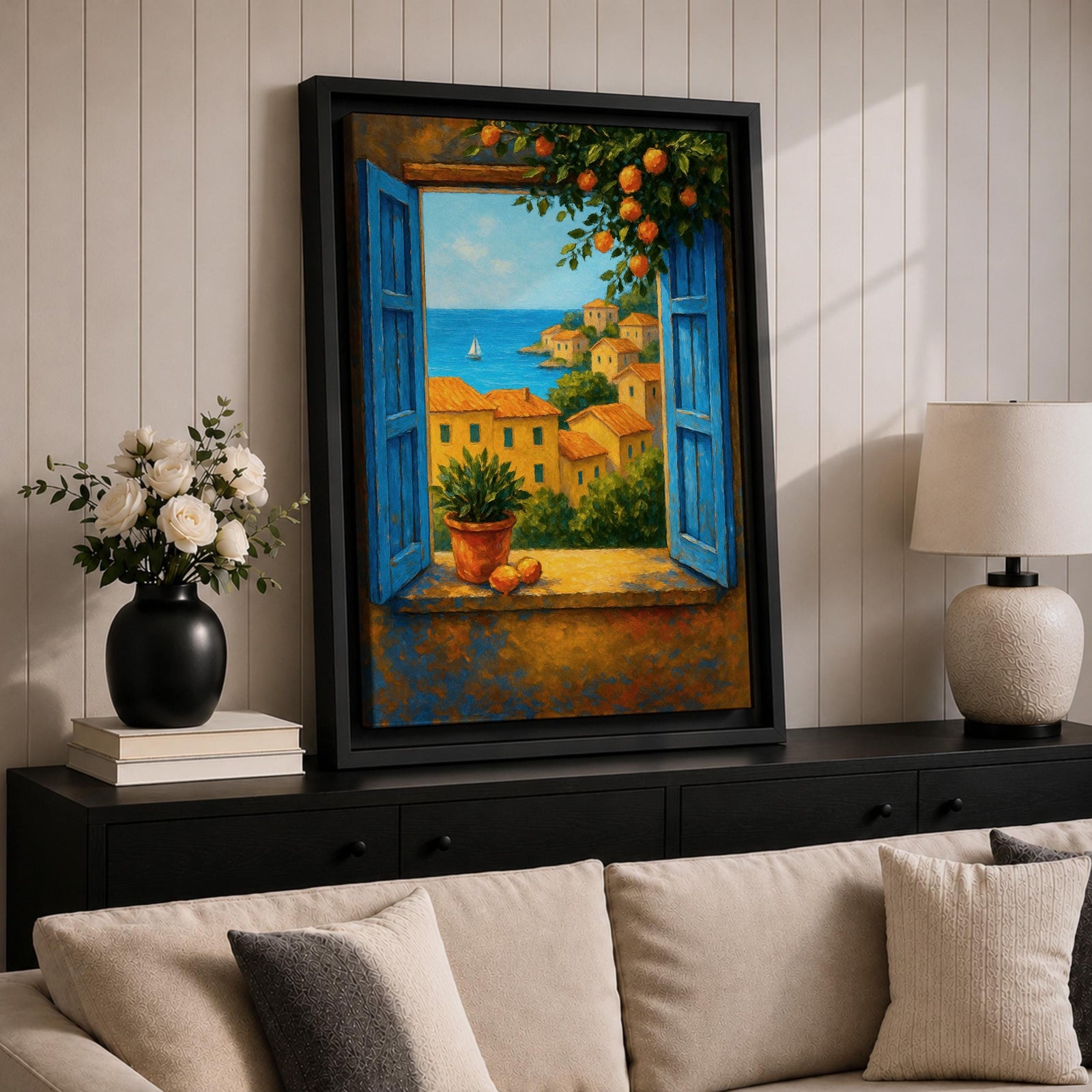A framed canvas painting depicting a Mediterranean window opening to a seaside coastal view with terracotta-roofed houses, lush greenery, and a distant sailboat on the blue sea, rendered in a realistic landscape style with vibrant colors and detailed brushwork.