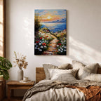 An impasto style framed canvas painting depicting a coastal sunset path bordered by vibrant wildflowers leading to a calm sea with distant mountains under a colorful sky. The textured brush strokes emphasize the natural landscape and seaside atmosphere.