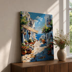 An impasto style painting depicting a charming Greek island village street with whitewashed buildings, colorful flowers in pots, balconies, and a view of the blue sea under a partly cloudy sky. The textured brushstrokes create a vivid Mediterranean coastal atmosphere.