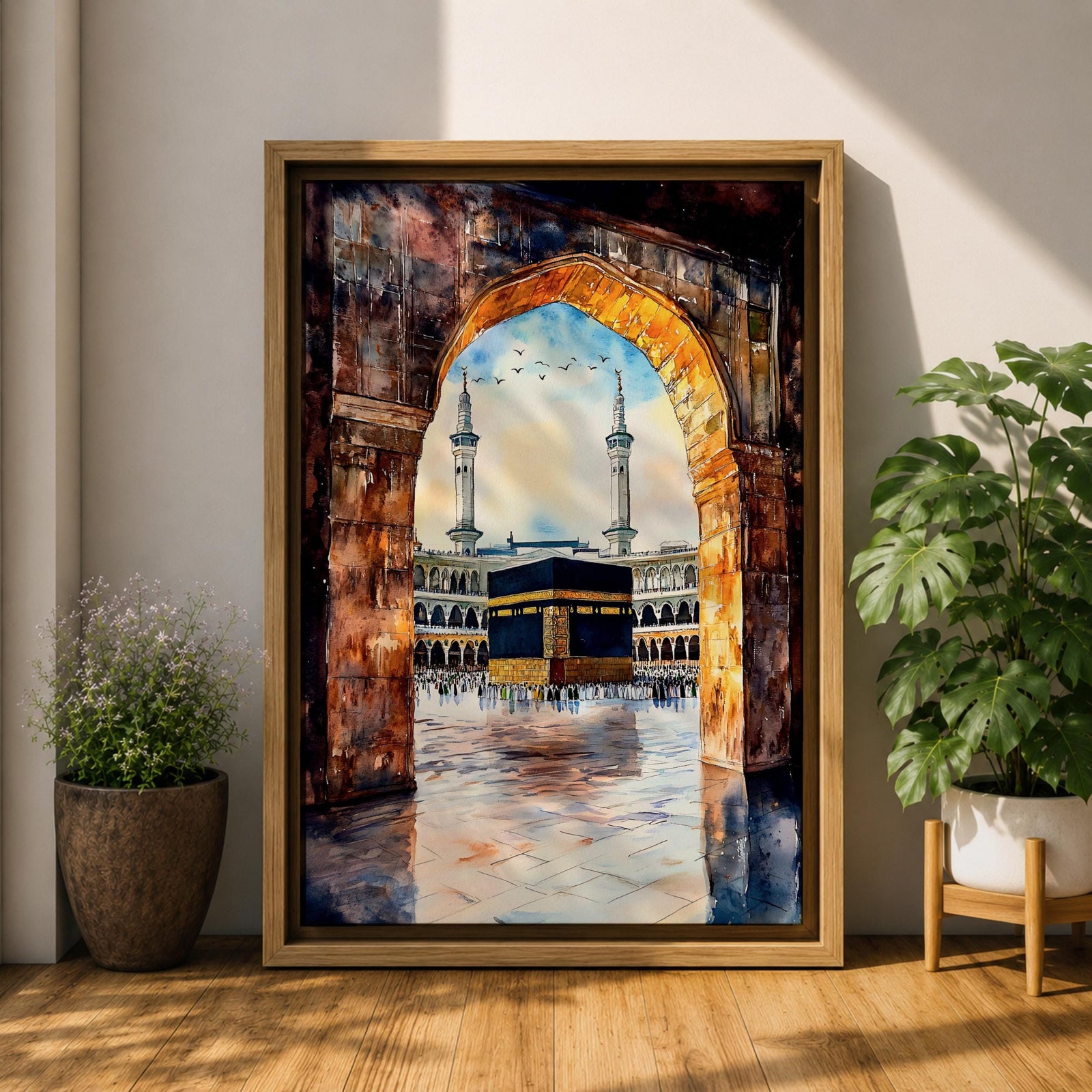 Watercolor-style painting of the Kaaba in Masjid al-Haram viewed through a large stone archway, showing the sacred courtyard with pilgrims and two tall minarets rising above the mosque.