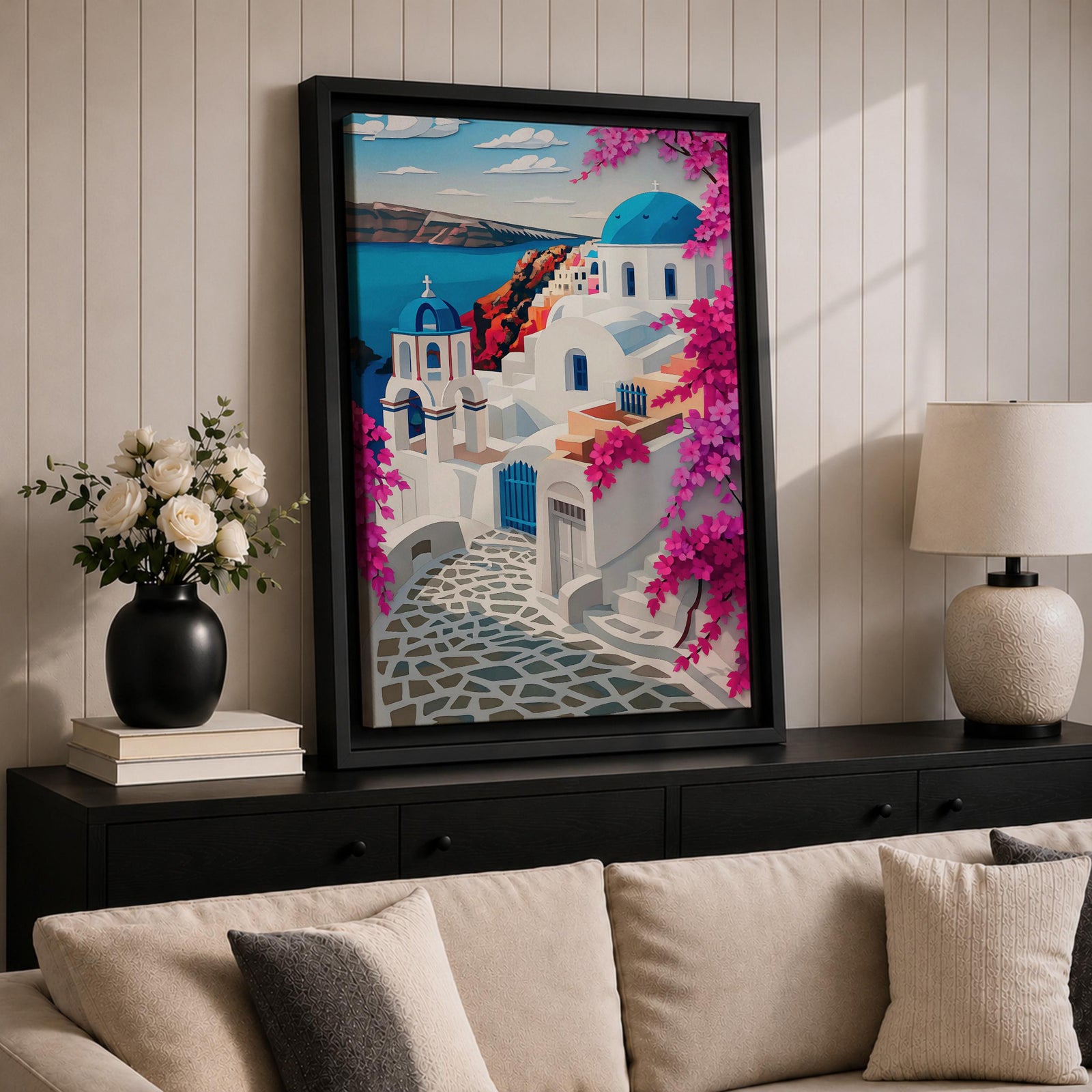A vibrant framed canvas depicting Santorini, Greece, featuring iconic white buildings with blue domes, winding cobblestone paths, and bright bougainvillea flowers overlooking a deep blue sea, rendered in a clean, graphic style emphasizing architectural shapes and Mediterranean coastal charm.