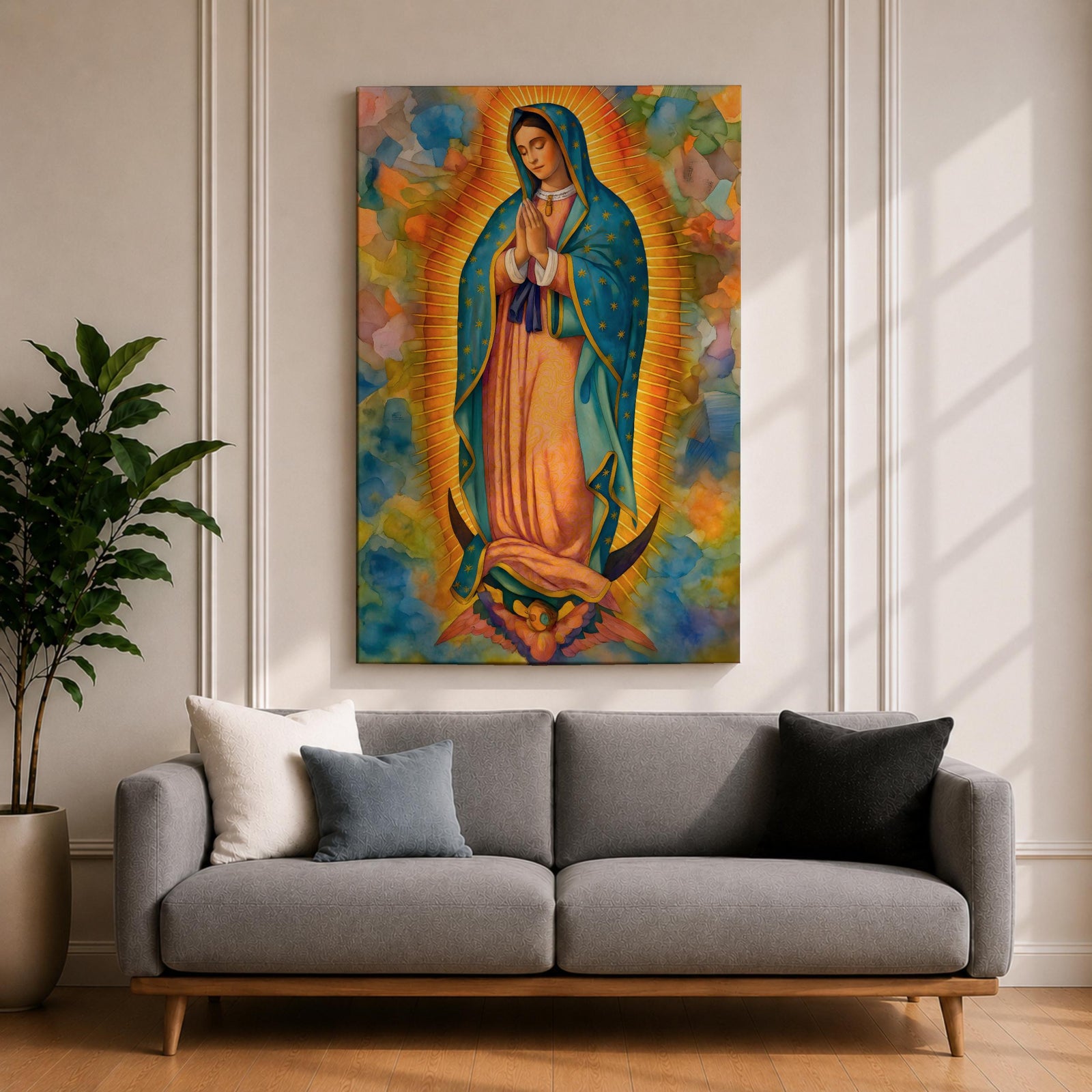 A vibrant framed canvas depicting Our Lady of Guadalupe, showing the Virgin Mary with hands clasped in prayer, wearing a blue mantle adorned with stars and a pink dress, surrounded by radiant golden rays and a colorful abstract background.