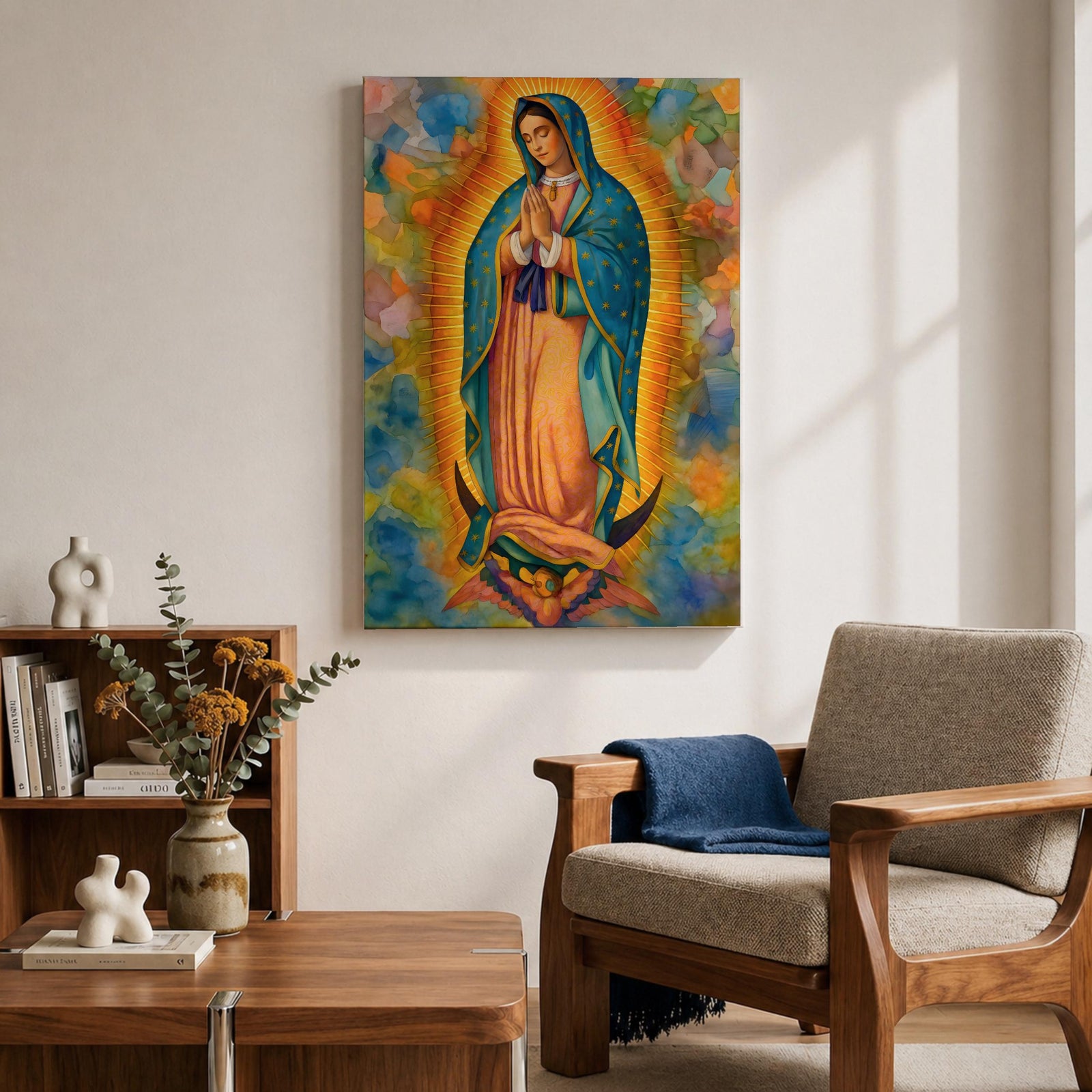 A vibrant framed canvas depicting Our Lady of Guadalupe, showing the Virgin Mary with hands clasped in prayer, wearing a blue mantle adorned with stars and a pink dress, surrounded by radiant golden rays and a colorful abstract background.