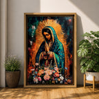 A vibrant framed canvas painting of Our Lady of Guadalupe depicts the Virgin of Guadalupe with hands clasped in prayer, wearing a teal mantle adorned with gold stars and surrounded by radiant light. The foreground features a colorful array of flowers, emphasizing the Catholic religious theme.