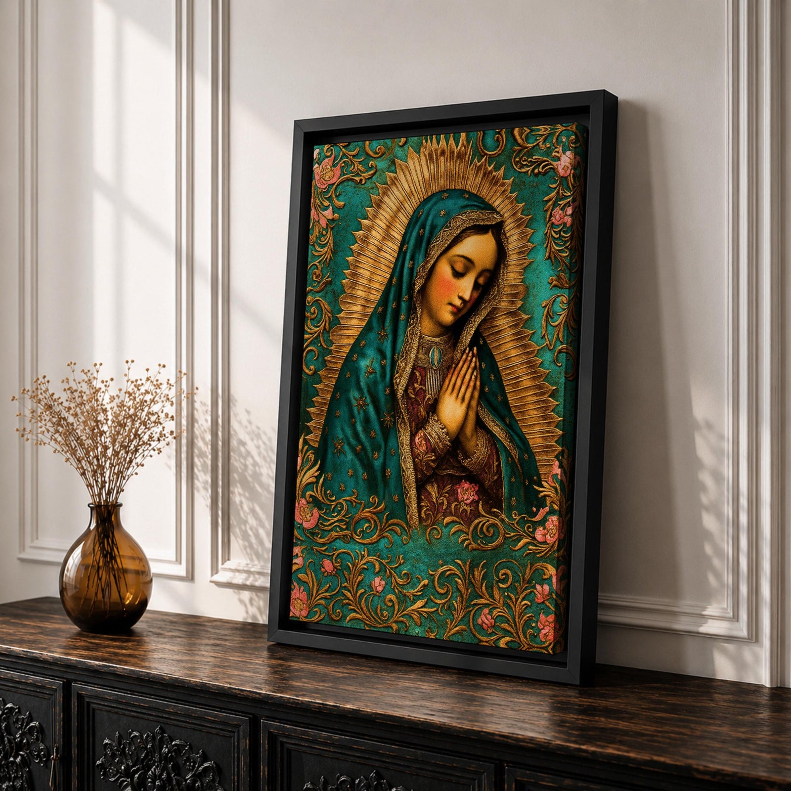 A vintage-style framed canvas depicting Our Lady of Guadalupe with her hands clasped in prayer, wearing a teal mantle adorned with stars and a golden halo radiating behind her. The artwork features intricate floral patterns surrounding the figure, emphasizing traditional Mexican Catholic iconography.