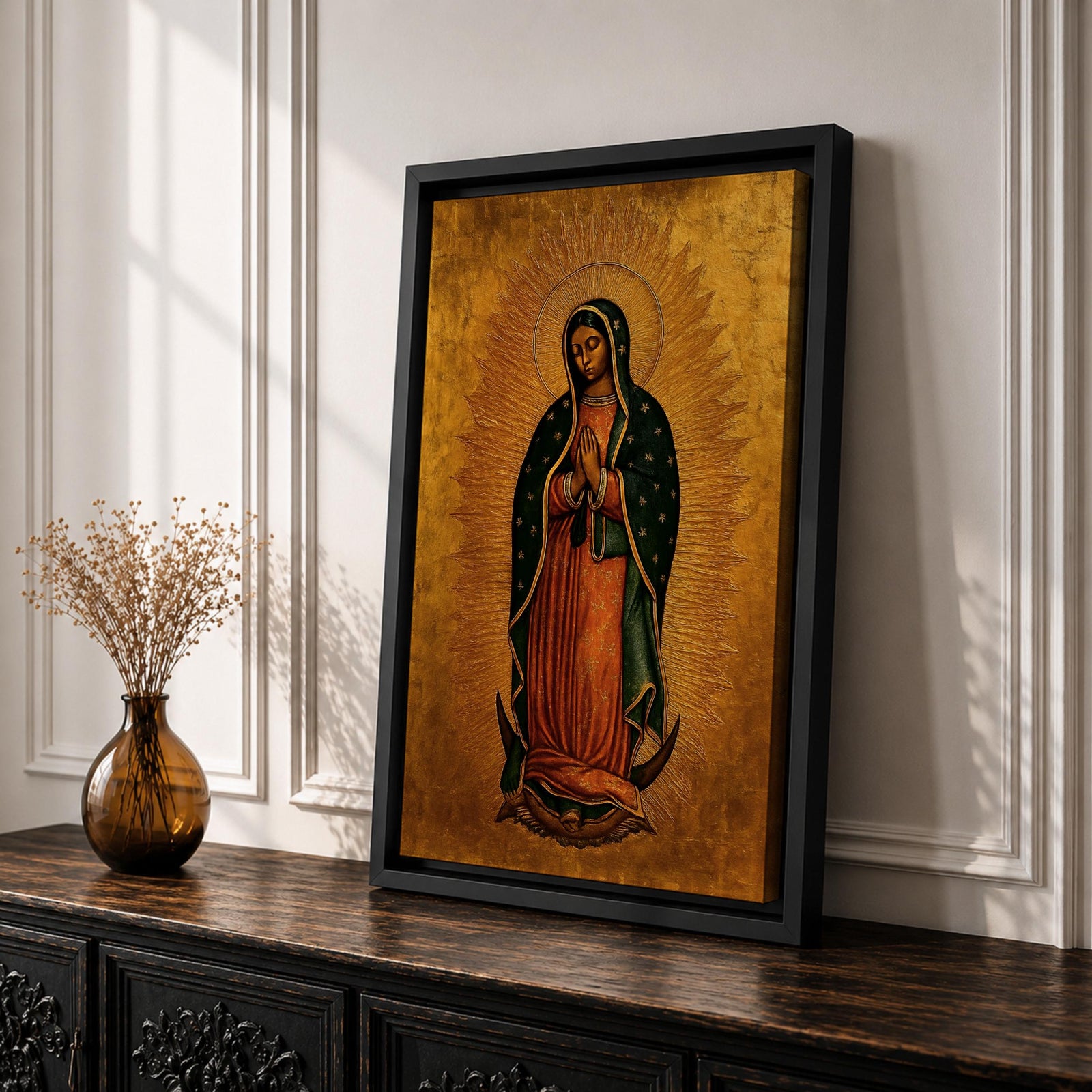 A traditional devotional depiction of Our Lady of Guadalupe standing with hands folded in prayer, wearing a rose colored gown and a teal mantle covered in gold stars, surrounded by radiant golden sun rays and standing above a crescent moon supported by an angel, rendered in classic Mexican Catholic icon style with rich colors and sacred symbolism.