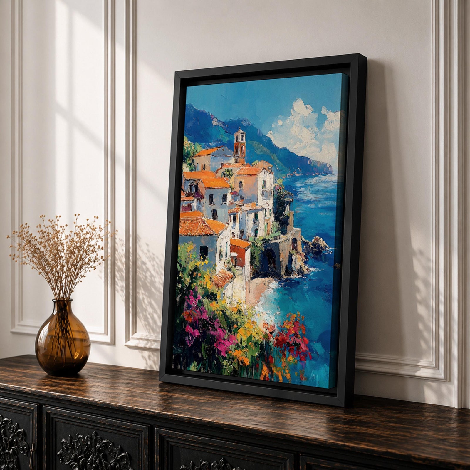 This impasto style framed canvas depicts the Amalfi Coast featuring a cluster of Italian villas with terracotta roofs perched on cliffs overlooking a vibrant blue Mediterranean sea under a partly cloudy sky, with colorful flowers in the foreground enhancing the coastal landscape scene.