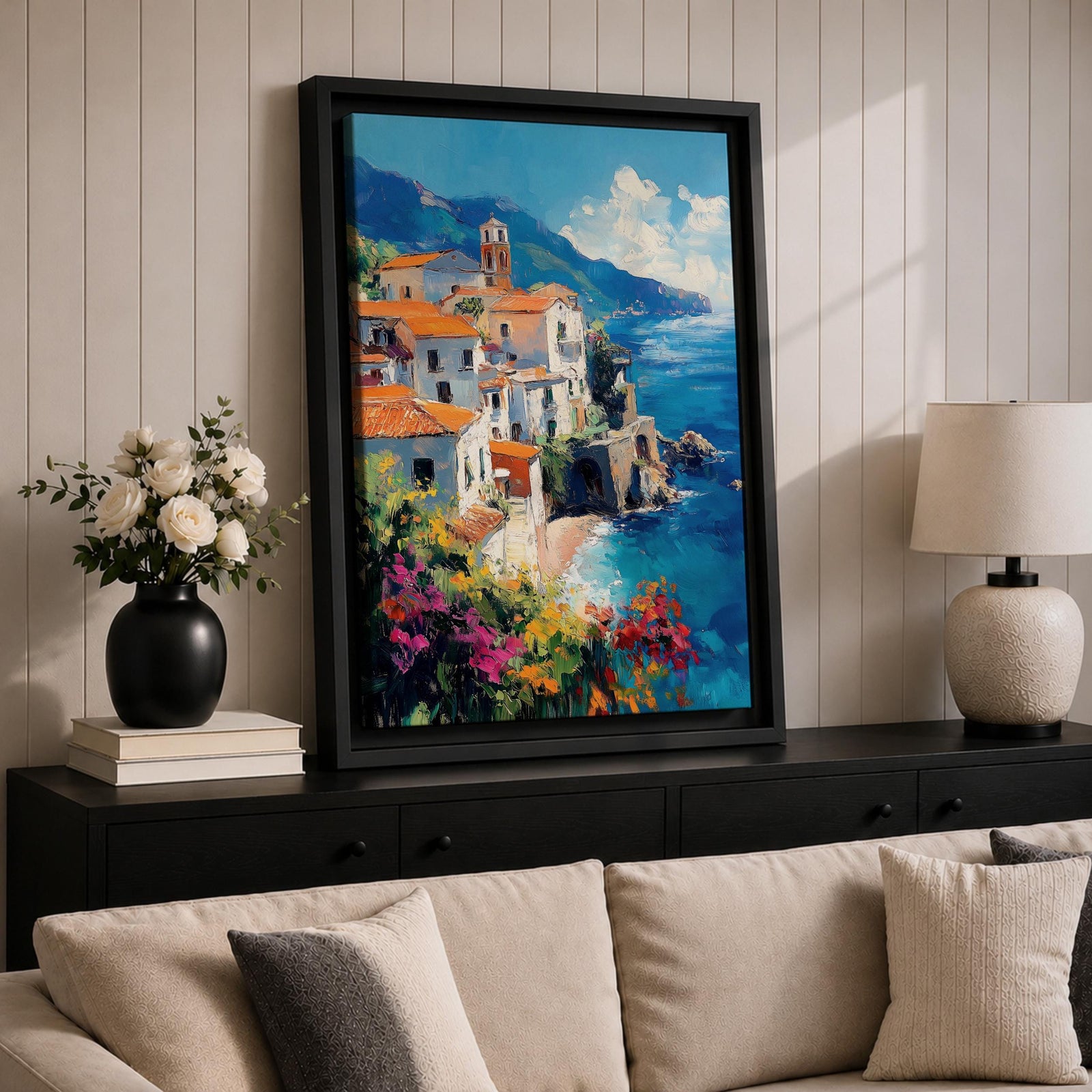 This impasto style framed canvas depicts the Amalfi Coast featuring a cluster of Italian villas with terracotta roofs perched on cliffs overlooking a vibrant blue Mediterranean sea under a partly cloudy sky, with colorful flowers in the foreground enhancing the coastal landscape scene.