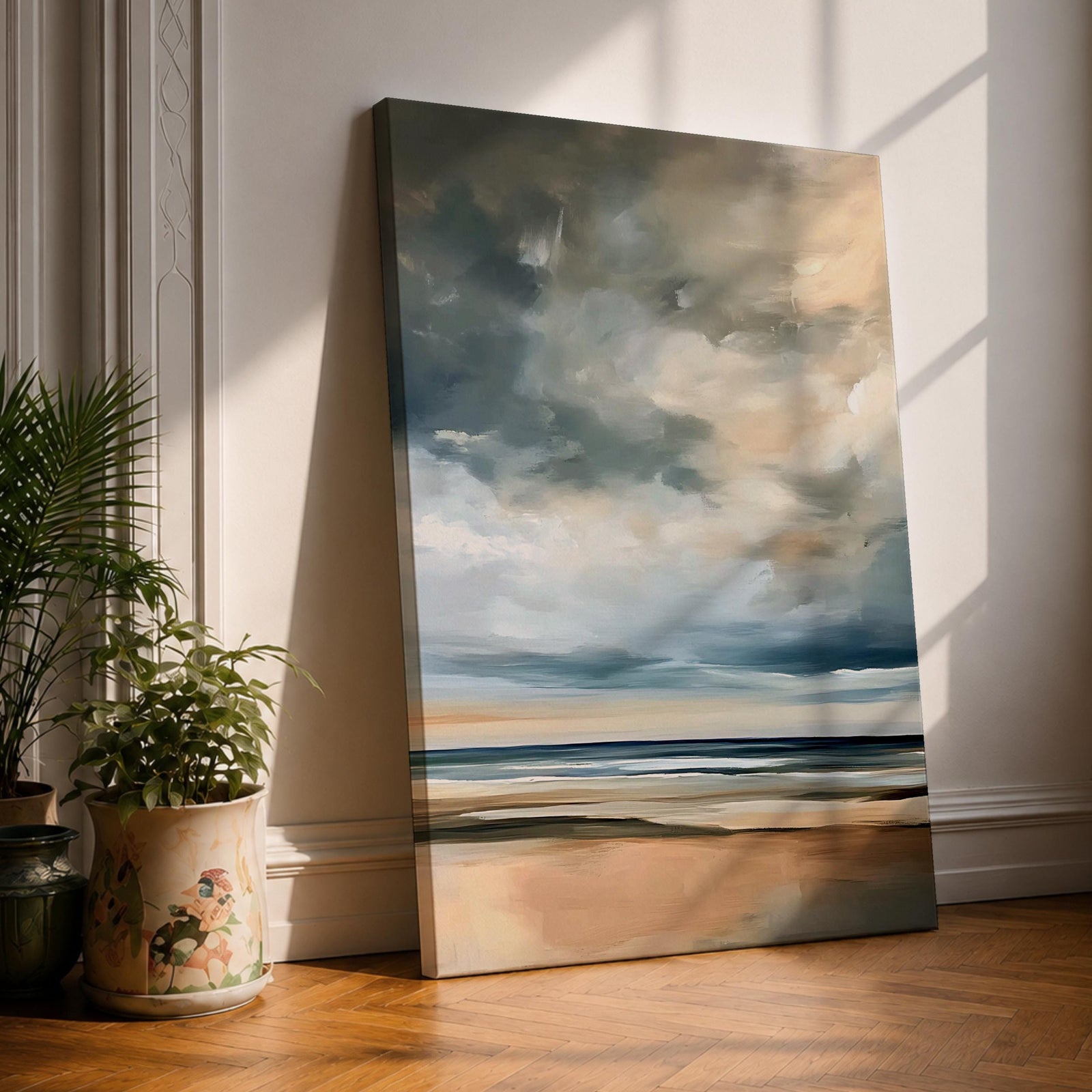 A framed canvas painting depicting a coastal seascape with a cloudy sky over a calm ocean and sandy beach. The artwork features a vintage style with soft brush strokes and muted tones, capturing the serene and expansive nature of the shoreline and sky.
