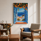 A vibrant framed canvas painting depicting an open Mediterranean-style window with blue shutters overlooking a coastal landscape. Above the window, ripe orange fruits hang from branches, framing a scenic view of white houses with terracotta roofs and a deep blue sea under a clear sky, rendered in a vivid, realistic style.