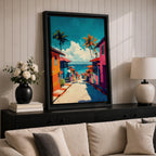 A vibrant painting depicting a tropical beach village with colorful houses lining a descending street toward the ocean. Palm trees rise above the rooftops under a bright blue sky with fluffy clouds. The artwork captures a lively coastal town atmosphere in a bold, illustrative style.