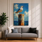 A framed canvas painting of a seagull perched on a weathered post against a bright blue sky with fluffy clouds and a distant ocean horizon. The artwork captures the bird in a realistic style with textured brushstrokes emphasizing the natural coastal scene.