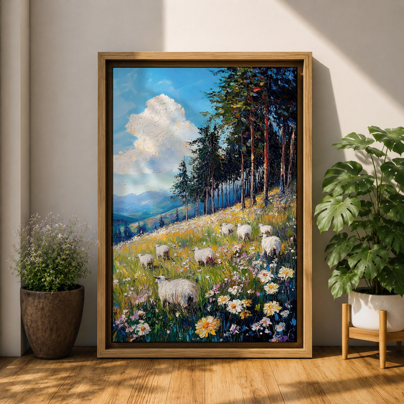 This impasto style framed canvas depicts a scenic landscape of sheep grazing in a meadow filled with wildflowers, bordered by tall trees and distant mountains under a bright blue sky with fluffy clouds, rendered with thick textured brushstrokes that emphasize the natural rustic setting.