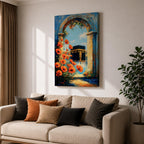 A vibrant painting depicting the Kaaba framed by an ancient stone arch adorned with bright orange flowers. The artwork captures the iconic Islamic holy site with a clear blue sky background, rendered in a realistic style emphasizing architectural and floral details.