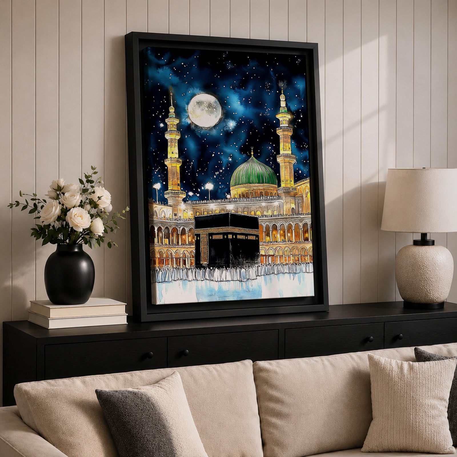 Painting of the Kaaba at Masjid Al Haram under a night sky filled with stars and a large full moon, surrounded by illuminated mosque arcades and tall minarets with pilgrims gathered around the sacred cube, while the green dome of Masjid Al Nabawi appears in the background within the composition.