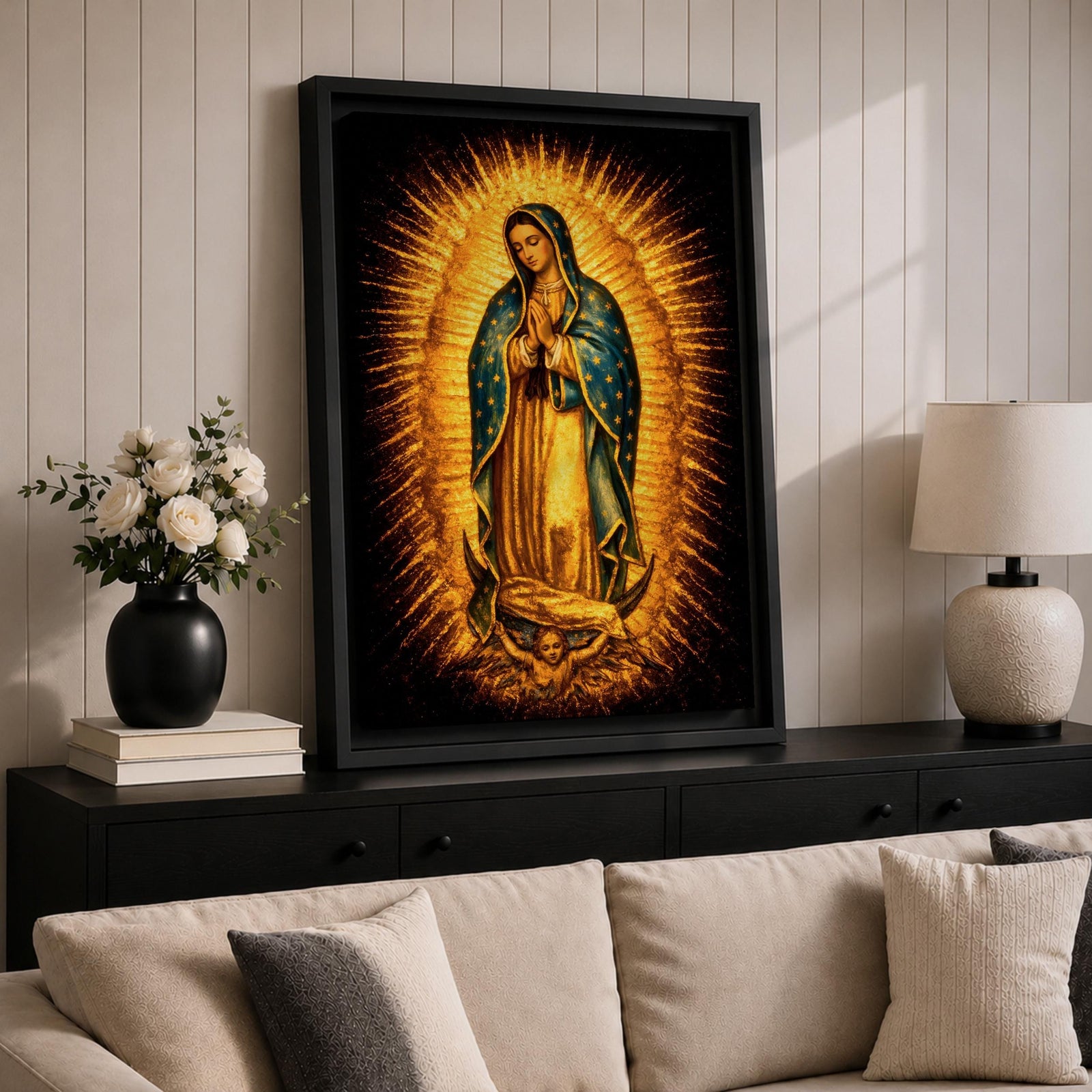 Traditional Our Lady of Guadalupe Catholic icon showing the Virgin Mary standing in prayer with hands clasped, surrounded by radiant sunburst rays. She wears a star covered mantle and flowing robe while standing on a crescent moon supported by an angel below, presented in a classic devotional religious composition associated with Mexican Catholic imagery.