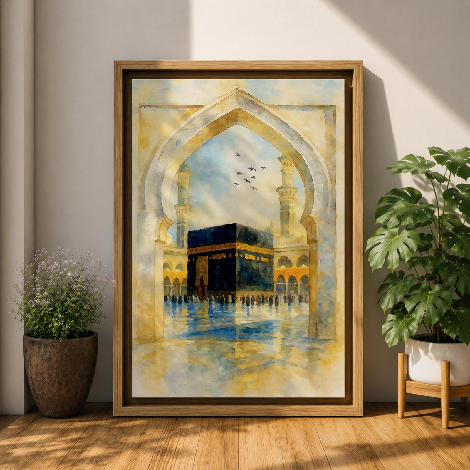 Soft watercolor artwork of the Kaaba at Masjid Al Haram framed by a Moorish pointed arch with mosque minarets and birds flying above the reflective courtyard.