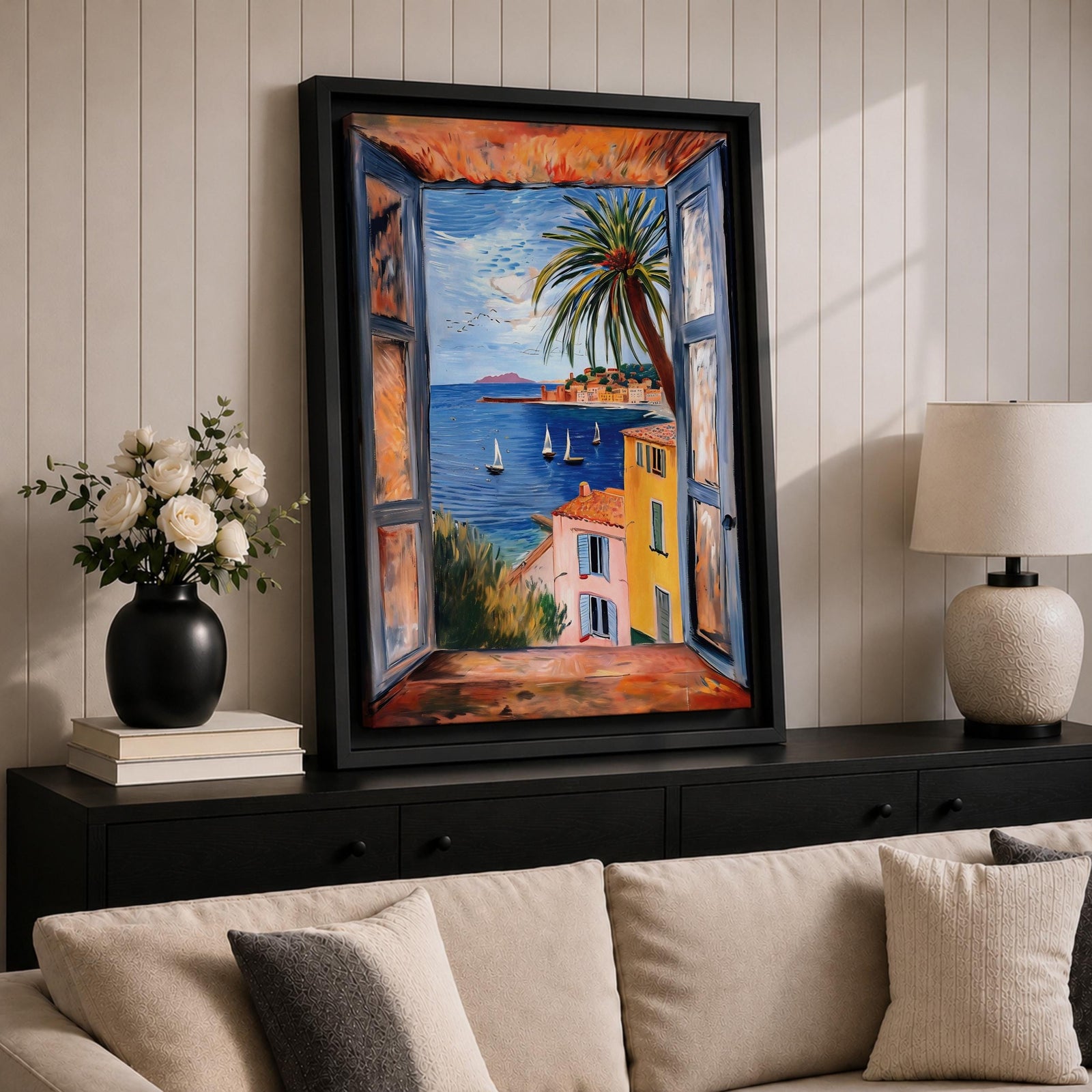 A framed canvas artwork depicting a coastal window view overlooking a Mediterranean ocean scene with sailboats on blue water, colorful buildings with terracotta roofs, and a palm tree, rendered in a realistic style capturing the serene seaside landscape.