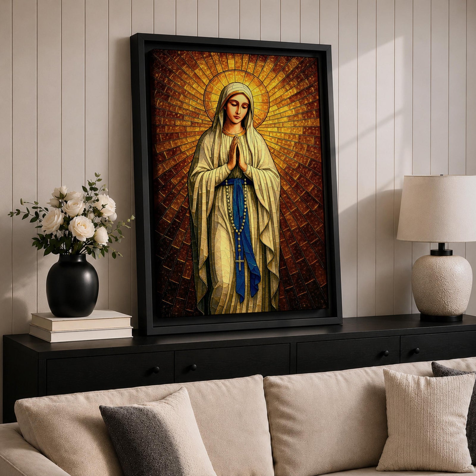 A stained glass style artwork depicting Our Lady of Fatima standing with hands clasped in prayer, wearing a flowing robe and a blue sash with rosary beads. The background features radiant golden mosaic tiles arranged in a halo pattern emphasizing the figure’s serene expression and sacred presence.