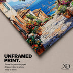 A vibrant framed canvas painting depicting a charming coastal village with stone-paved streets, terracotta rooftops, lush greenery, colorful flowers, and sailboats on a deep blue sea under a clear sky, rendered in a detailed, realistic style capturing Mediterranean summer ambiance.