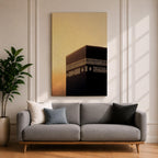 Minimalist artwork of the Kaaba at Masjid Al Haram in Mecca showing the black cubic shrine with gold calligraphy bands against a dramatic golden sunset sky and soft clouds.