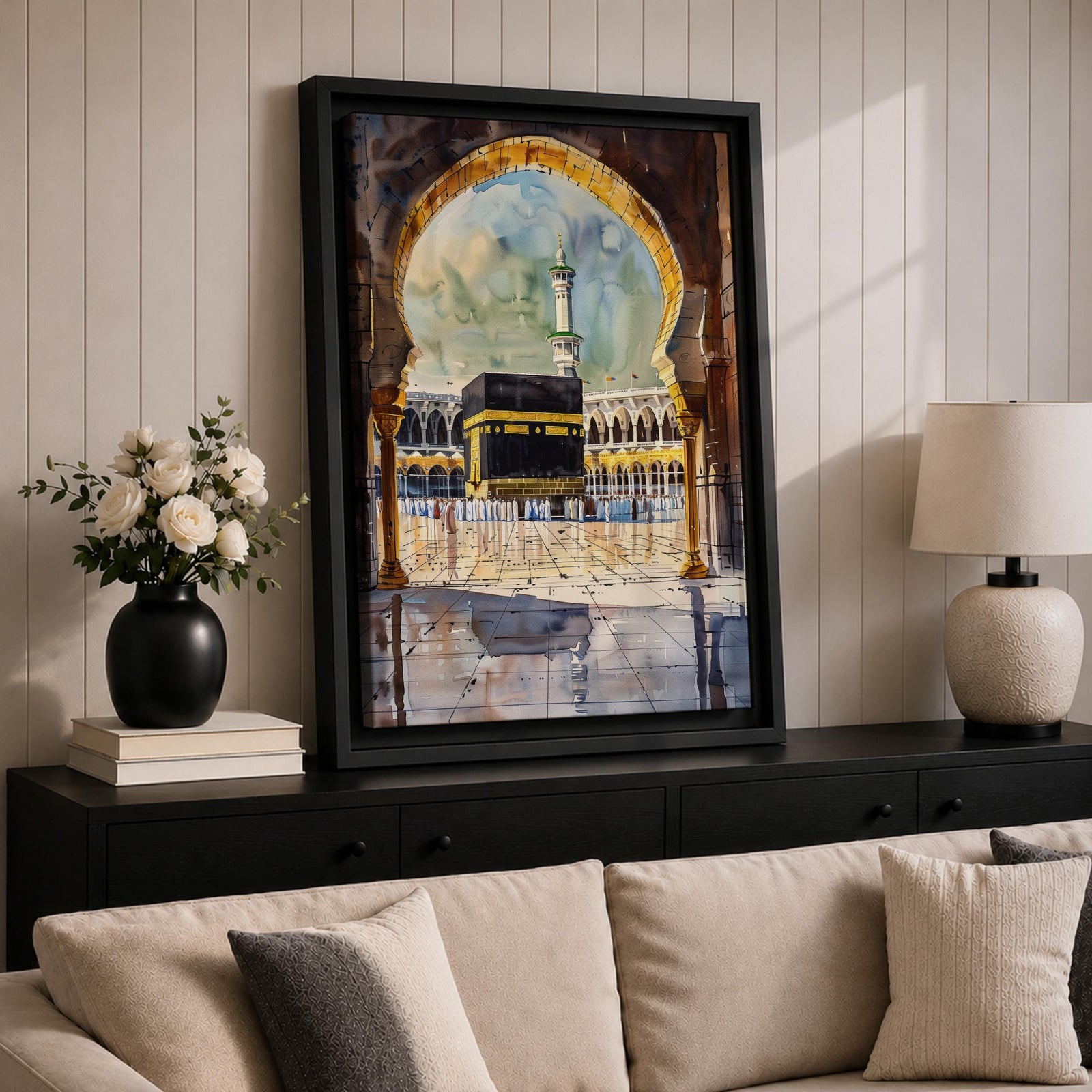 Watercolor-style painting of the Kaaba at Masjid Al Haram in Mecca viewed through a large mosque archway, with pilgrims standing in the courtyard and a tall minaret rising behind the sacred shrine.