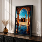 Framed wall art showing the Kaaba at Masjid Al Haram in Mecca viewed through a grand marble archway with columns and reflective courtyard tiles under a bright blue sky.