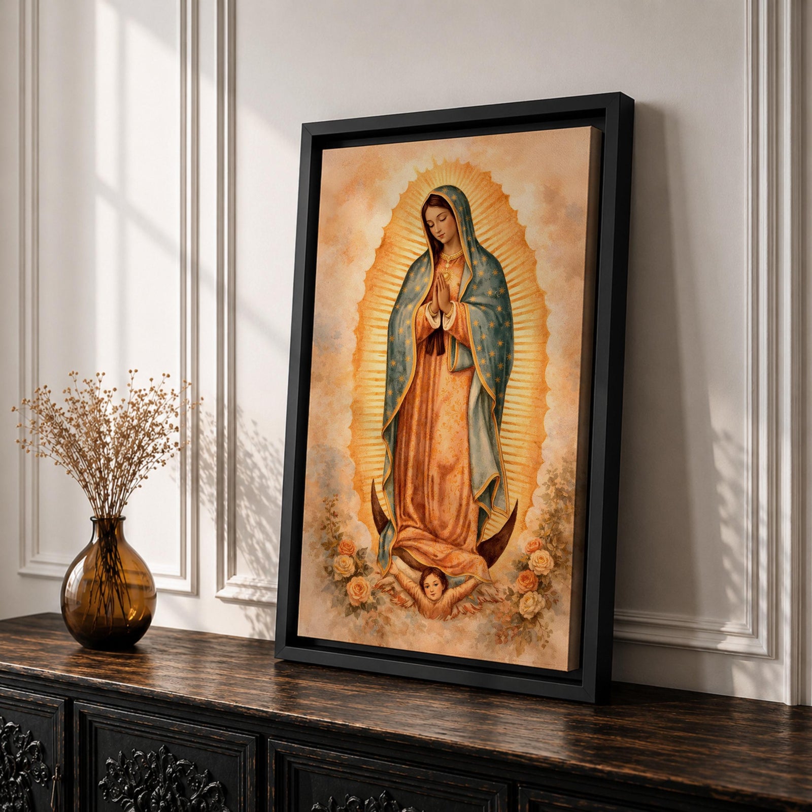 Painting of Our Lady of Guadalupe standing in a prayer pose with hands clasped and head bowed, wearing a flowing rose colored gown and a blue mantle decorated with stars, surrounded by radiant golden rays forming an oval halo, standing on a crescent moon supported by a small angel in traditional Catholic devotional style.