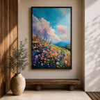 A vibrant impasto painting of a wildflower meadow featuring dense clusters of colorful flowers under a bright blue sky with fluffy clouds. The textured brushstrokes create depth and movement, capturing a lively natural landscape scene with rolling hills in the distance.