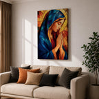 Stained glass style painting of the Virgin Mary shown in profile with head bowed and hands clasped in prayer, wearing a blue mantle and red garment, surrounded by geometric stained glass panels forming a radiant halo like background in a devotional Catholic Marian composition.