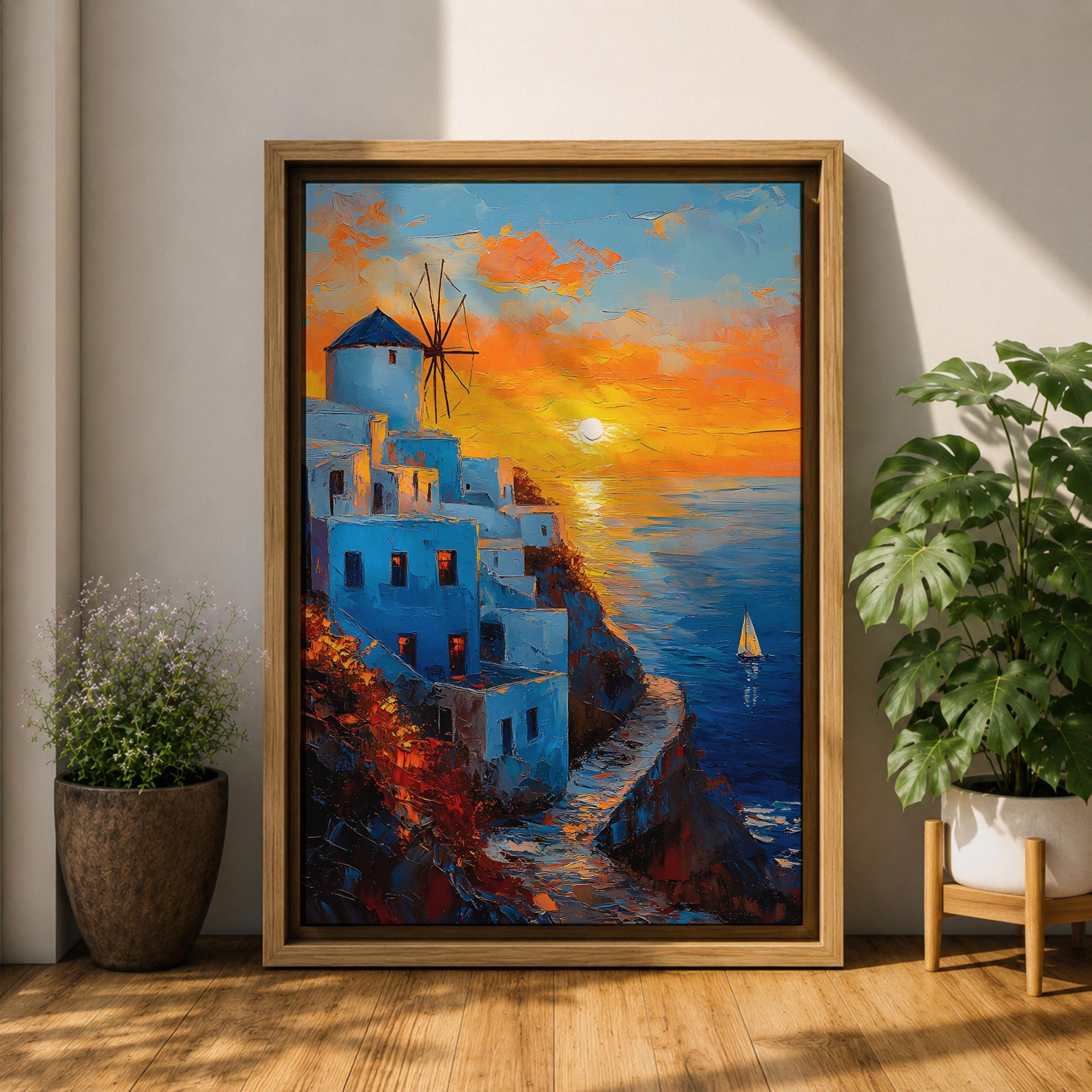 An impasto style framed canvas painting depicting a Santorini sunset over whitewashed buildings with a windmill on a cliffside overlooking the sea. The vibrant sunset sky reflects on the water with a small sailboat visible, capturing a Mediterranean coastal landscape scene with textured brushstrokes.