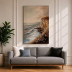 A vintage style framed canvas painting depicting a cliffside ocean seascape with waves crashing against rocky shores and wildflowers in the foreground. The textured brushwork captures the coastal landscape atmosphere with muted tones and a soft sky blending into the horizon.